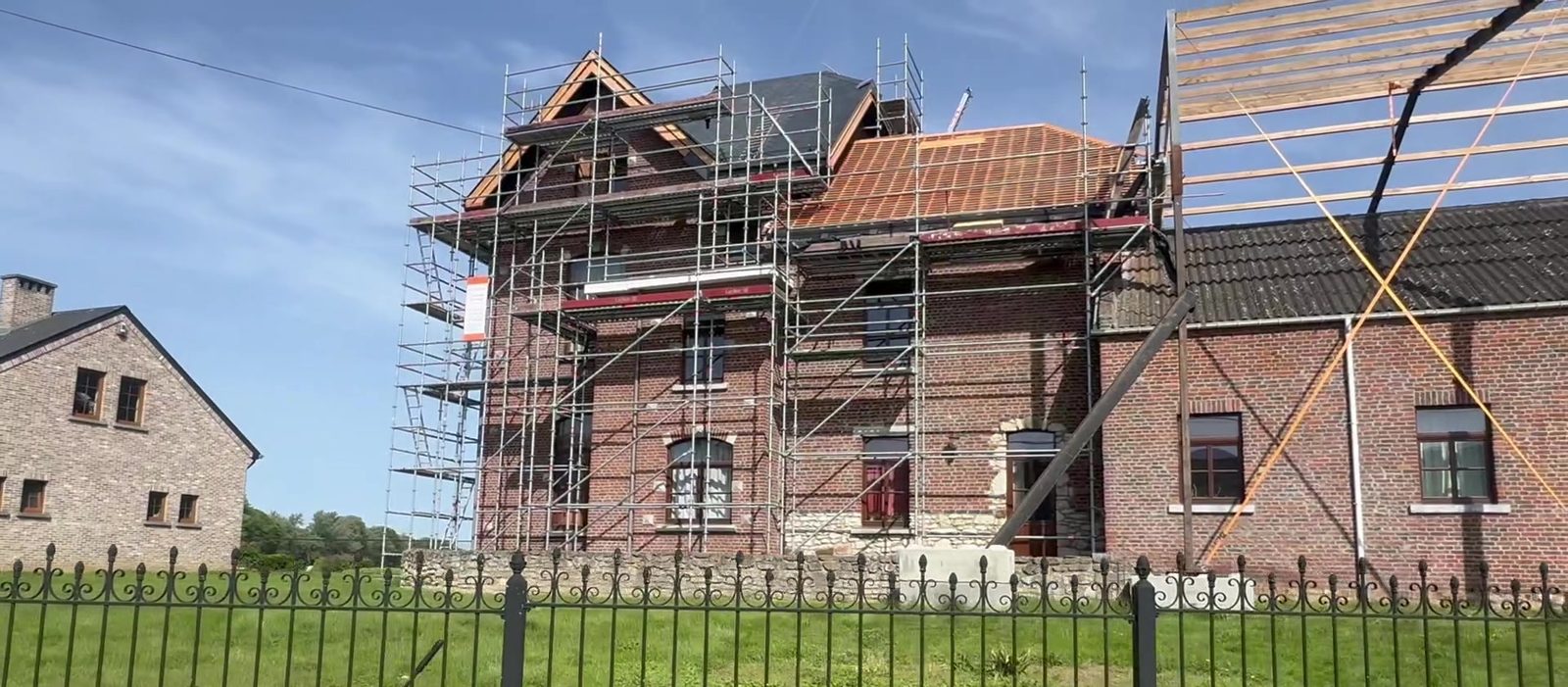 Vue d'ensemble du chantier — ferme historique en rénovation, scaffolding complet autour de la tour centrale